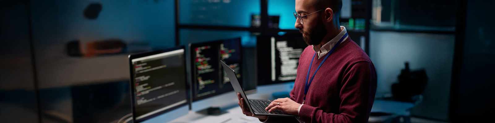 Man on laptop surrounded by computers computer science