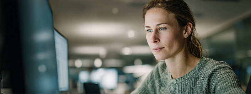 Computer science professional working in a modern office, reviewing ethical data frameworks on screen, surrounded by icons for data privacy, AI ethics, and digital inclusivity.